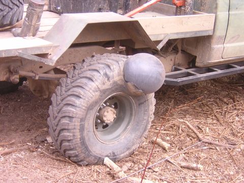 1985 Ford Bronco - A close-up view of a tire on a heavy-duty vehicle, showing its tread and a peculiar spherical attachment.