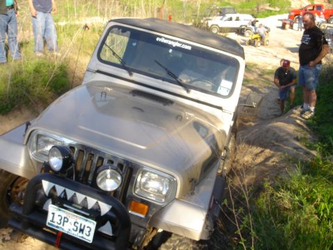 2002 Jeep Wrangler - Jeep Wrangler stuck in a ditch with other vehicles and people around.