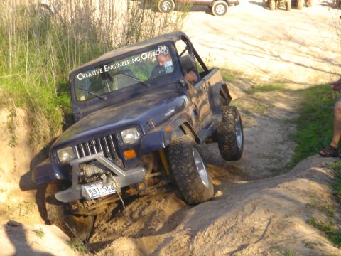 2002 Jeep Wrangler - Jeep Wrangler navigating a challenging off-road course with a driver inside.