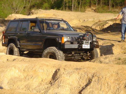 2002 Jeep Wrangler - A modified Jeep Cherokee XJ tackles an off-road course, demonstrating its capabilities on challenging terrain.