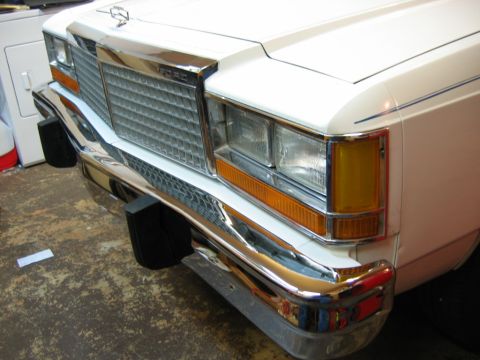 1985 Ford LTD Crown Victoria - Close-up of a white Ford Crown Victoria's front end, showing the grille and bumper details.
