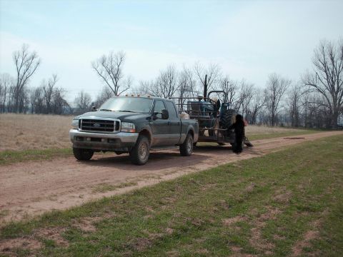 1993 Ford Bronco - A full shot with a tiny tractor in tow.