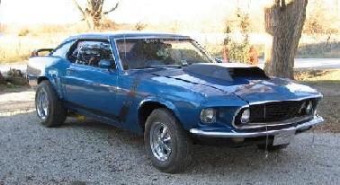1983 Ford Bronco - This blue 1969 Ford Mustang Boss 302 features a prominent hood scoop and is captured in a three-quarter front view.