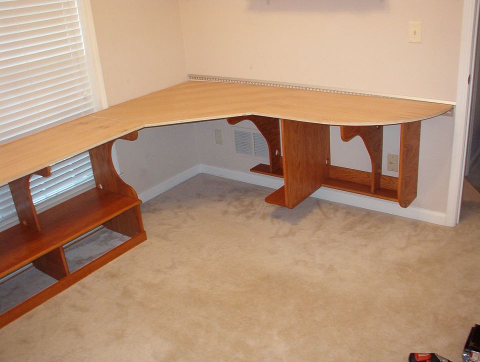 The smaller holes at the bottoms of the verticals are for power cords to run along the wall on the little shelf.  The larger ones up high are for data cables.  Nothing will be on the carpet but the chairs & some rolling storage carts that fit under the desk.