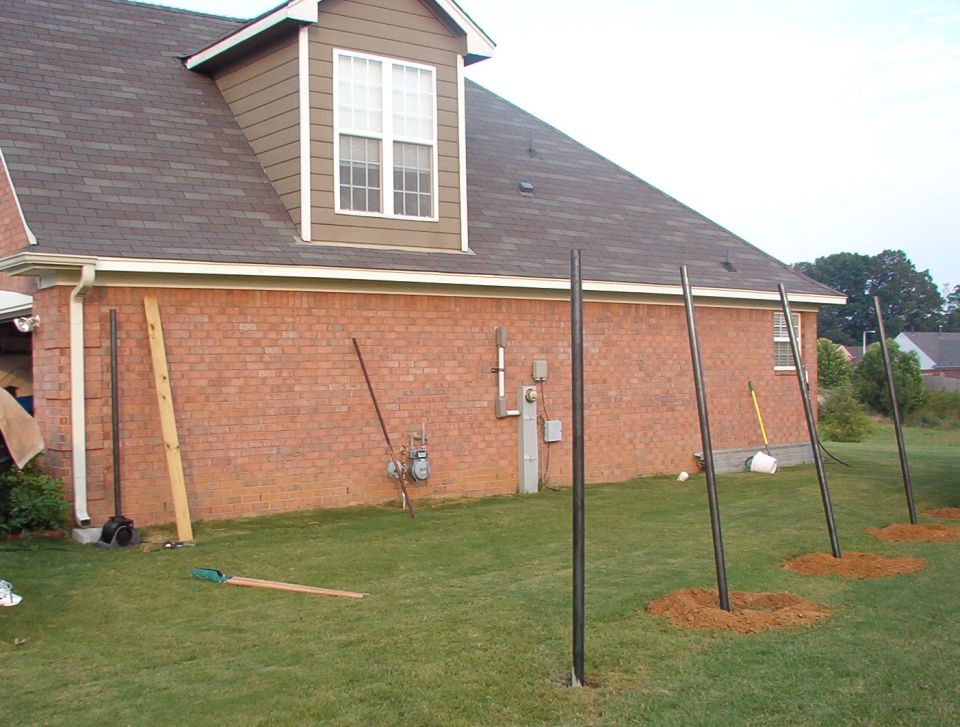 The hole by the house was the worst because the auger kept hitting the slab, and every time it bound up, my knuckles hit the bricks.  I'm surprised I had any meat left on them.