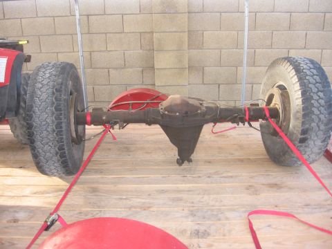 1990 Ford Bronco - A rear axle assembly with attached wheels is strapped to a wooden platform.