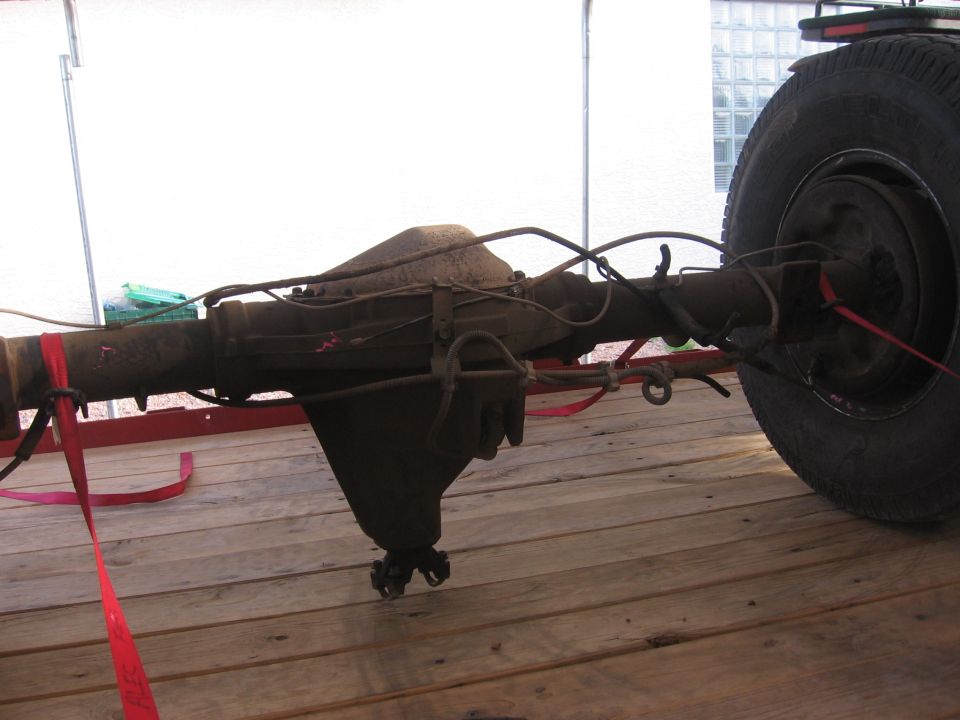 Rear axle assembly with a tire, secured with red straps