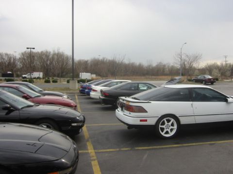 1993 Ford Probe - A line of Ford Probes are parked in a lot under an overcast sky.