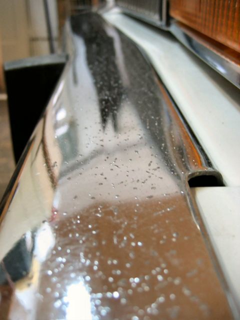 1985 Ford LTD Crown Victoria - Close-up of a chrome front bumper, showing water spots and reflections.