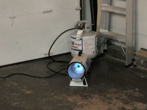 1985 Ford LTD Crown Victoria - A propane tank and a portable heater are positioned in front of a garage door.