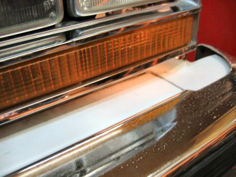 1985 Ford LTD Crown Victoria - Close-up view of a vehicle's front bumper and amber turn signal assembly.