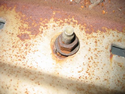 1985 Ford LTD Crown Victoria - Rusted metal surface shows a bolt, nut, and washer, indicating wear and age.