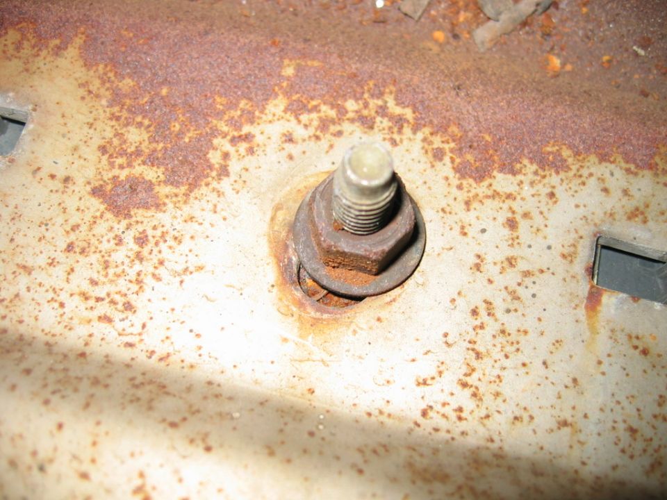 Close-up of a rusted metal surface with a bolt, nut, and washer