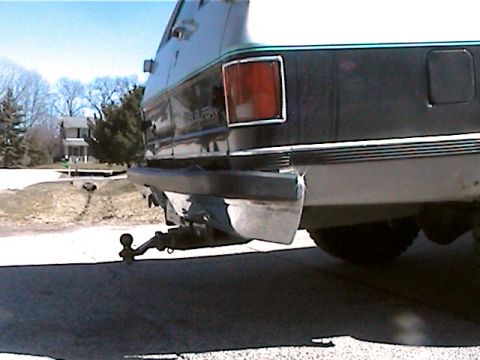 1977 Ford F-150 - Rear view of a dark green SUV, showing its trailer hitch and bumper.
