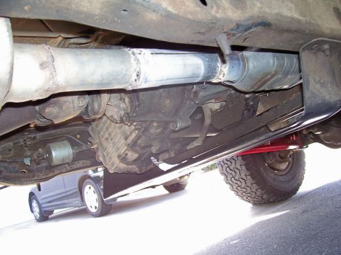 1991 Ford Bronco - The photo shows the undercarriage of a vehicle, focusing on the exhaust system and transmission components.