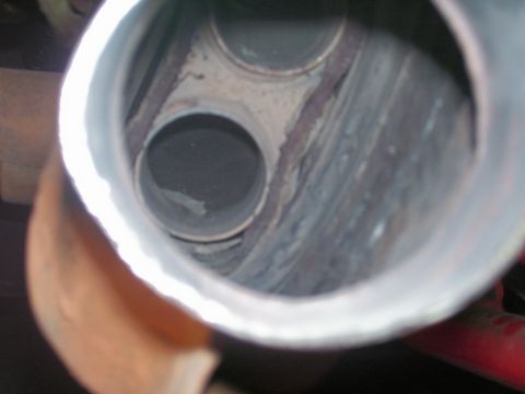 1991 Ford Bronco - Close-up view inside a dual exhaust pipe, showing the internal structure and signs of use.