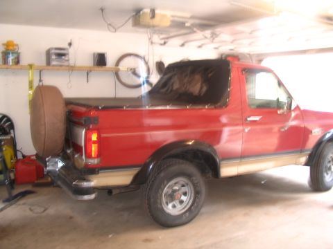 1989 Ford Bronco - This 1989 Ford Bronco is parked in a garage, showing its rear profile and spare tire.