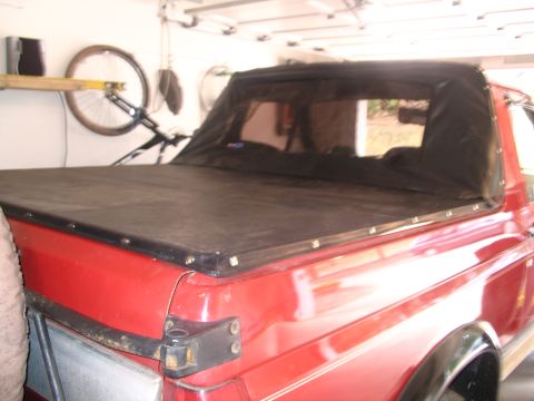1989 Ford Bronco - Rear view of a red 1989 Ford Bronco with a black soft tonneau cover.
