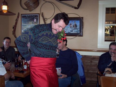 2001 Ford Crown Victoria - A man playfully holds flowers in his mouth while dining with friends at a restaurant.