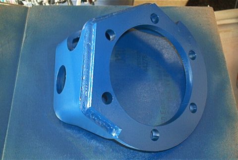 1986 Ford Bronco - A blue painted metal bracket with bolt holes is shown up close.