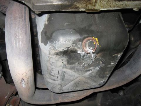 2000 Jeep TJ - Close-up of the oil pan and exhaust system, with visible markings and a drain plug.