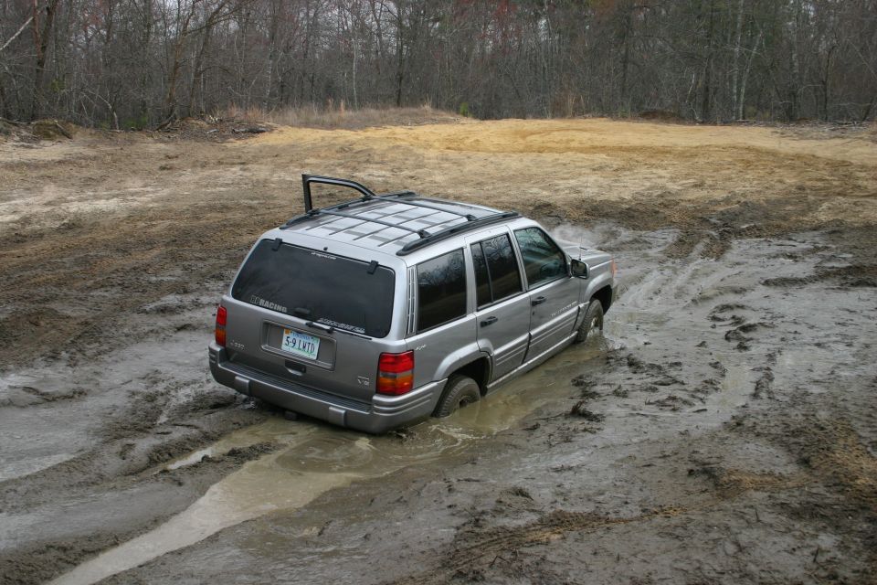 Silver SUV stuck in mud, rear view, license plate 5-9 LMTD