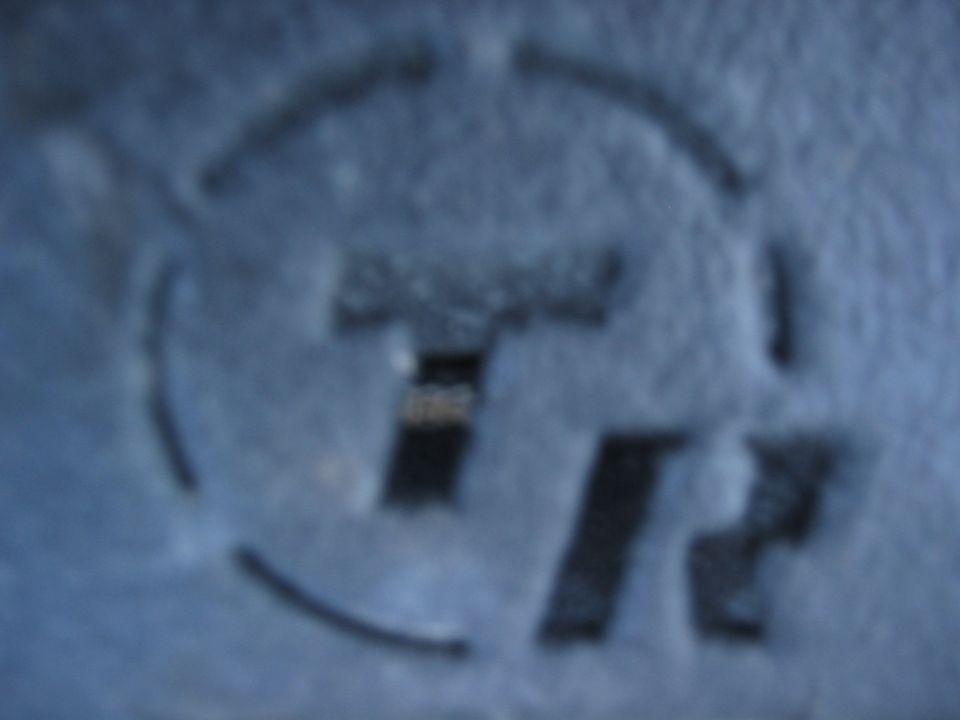 Stenciled letters TR on a blue surface