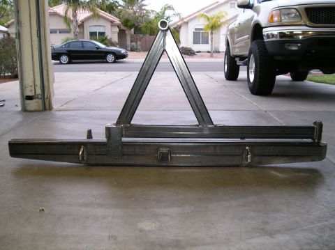 1993 Ford Bronco - A custom metal bumper assembly is shown in a garage, with a pickup truck visible in the background.