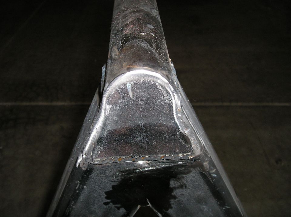 Close-up of fresh welds capping steel tube fabrication on a shop floor