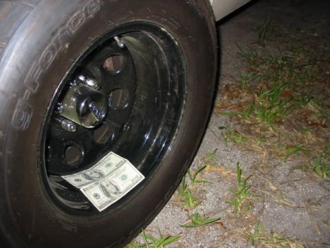1997 Ford Crown Victoria - A close-up view of a vehicle's wheel shows two $100 bills tucked inside.