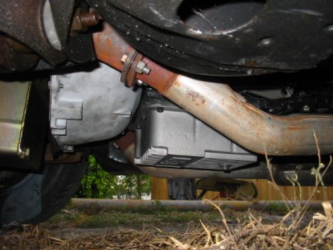 1985 Ford Crown Victoria LTD - Underside view of a vehicle's transmission and exhaust system, with visible text on the transmission pan.