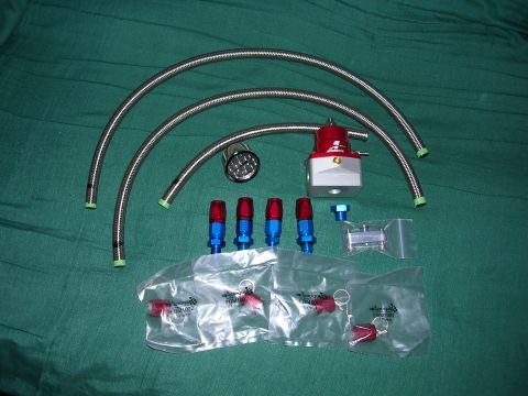 1996 Ford Probe - A collection of automotive fuel system components, including a red and silver fuel pressure regulator and braided hoses.