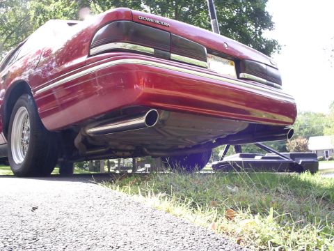 1995 Ford Crown Victoria - Rear view of a red 1995 Ford Crown Victoria, showing its dual exhaust system and taillights.