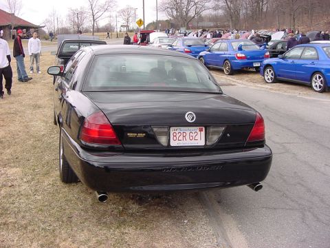 1995 Ford Crown Victoria - A black sedan with a 'Marauder' badge is parked on the side of the road, with other vehicles in the background.