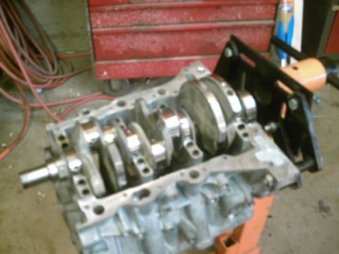 1994 Mazda MX-3 - Engine block and crankshaft assembly on an engine stand in a workshop.