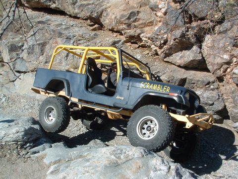 1981 Ford F-150 - Modified Jeep CJ-8 Scrambler tackling a challenging rocky trail.