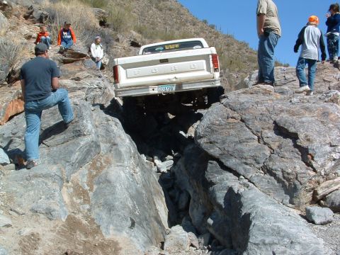 1981 Ford F-150 - White Ford F-Series truck is shown attempting to navigate a difficult rocky terrain.