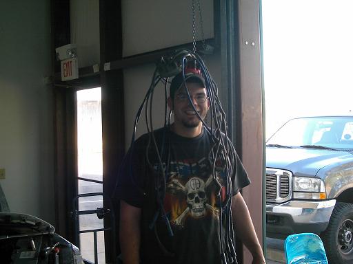 Gray truck front view with man wearing spark plug wires