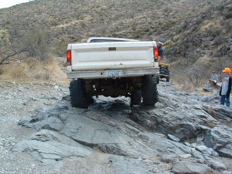 1981 Ford F-150 - A white Ford pickup truck navigates a rocky trail with another vehicle visible in the background.