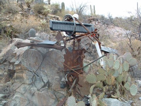 1981 Ford F-150 - A collection of rusted metal parts and a label are assembled into a sculpture in a dry, rocky environment.