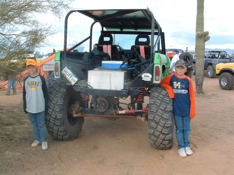 1981 Ford F-150 - Two children pose with a heavily modified off-road vehicle in a desert environment.