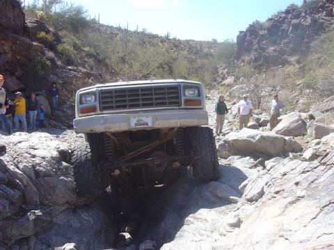 1981 Ford F-150 - A modified truck navigates a challenging rocky trail in a desert canyon environment.