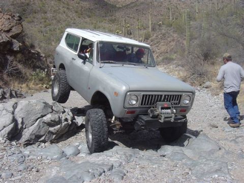 1981 Ford F-150 - An International Scout II is shown tackling a difficult rocky trail in a desert environment.