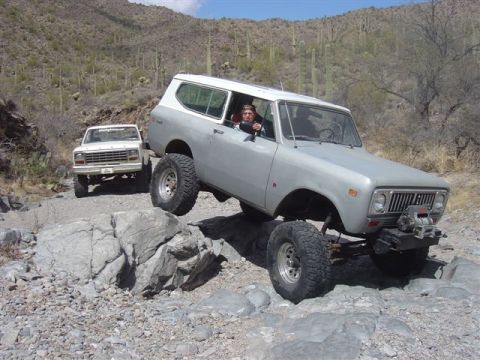 1981 Ford F-150 - An International Harvester Scout II navigates a rocky trail, with a Ford pickup truck following in the background.