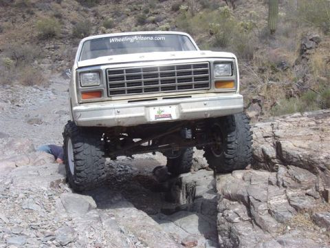 1981 Ford F-150 - White Ford pickup truck navigating difficult rocky terrain off-road.