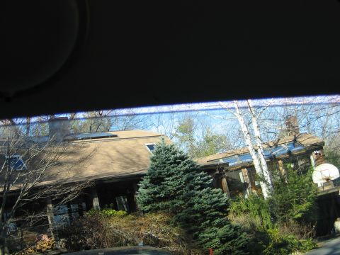 1995 Ford Bronco - A house surrounded by trees and foliage, with a basketball hoop visible in the yard.