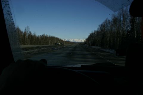 2003 Jeep TJ - Driving on a highway through a forested area towards snow-capped mountains.