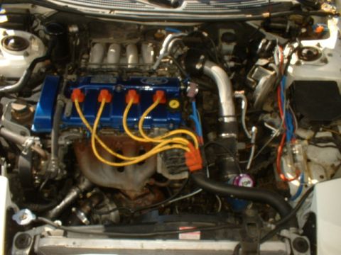 1993 Ford Probe - Engine bay of a 1993 Ford Probe, showing the blue valve cover and yellow spark plug wires.