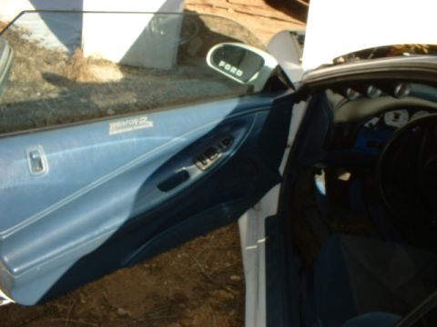 1993 Ford Probe - Interior view of a blue door panel with a "WEAPON R" badge and a Ford side mirror, revealing dashboard gauges.