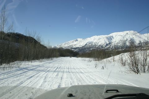 2003 Jeep TJ - Driving on a snowy road with mountains in the background. Another vehicle is ahead.
